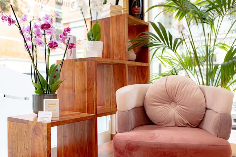 Modern living room with pink armchair, wooden shelving unit with purple orchids and potted plants